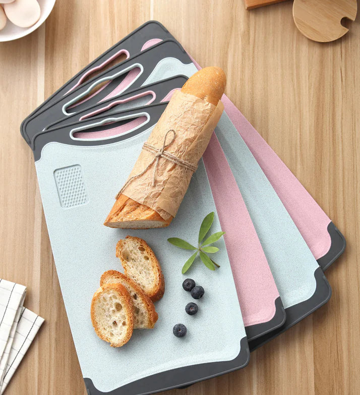 Set of silicone cutting boards with bread and vegetables on a wooden surface